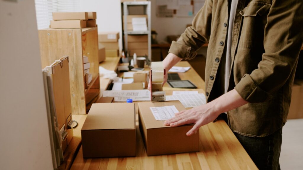 taping a shipping label onto a cardboard box