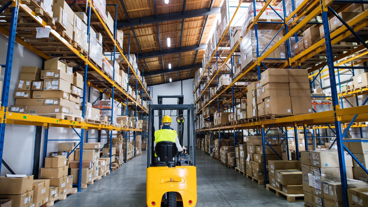 Rear view of a worker operating a yellow forklift